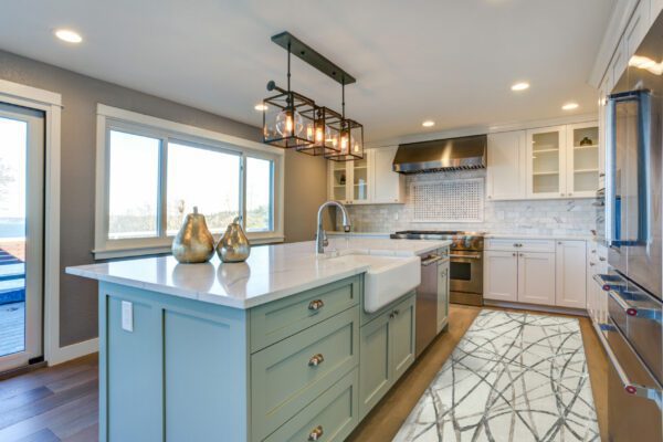 Beautiful kitchen room with green island and farmhouse sink.
