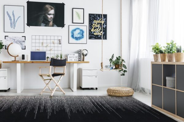 Modern home office with desk, chair, posters and big window