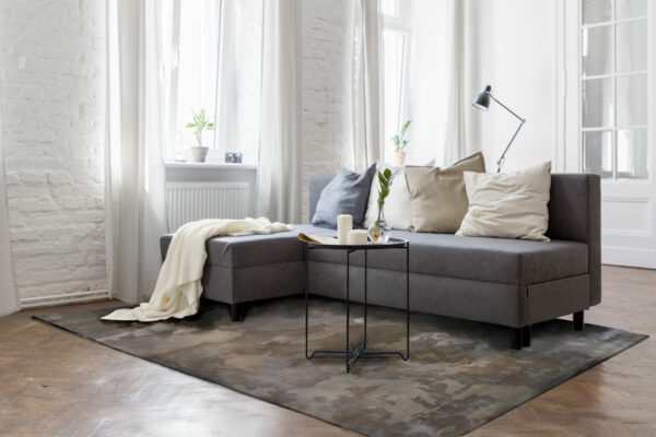 Industrial style living room with corner sofa, wooden parquet and brick wall