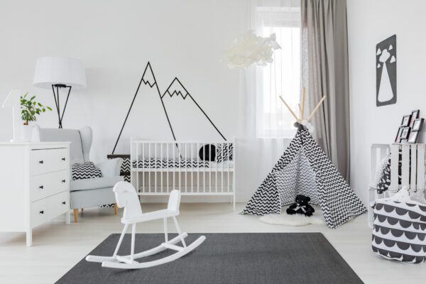 Child room with white furniture, carpet, tent and wall sticker